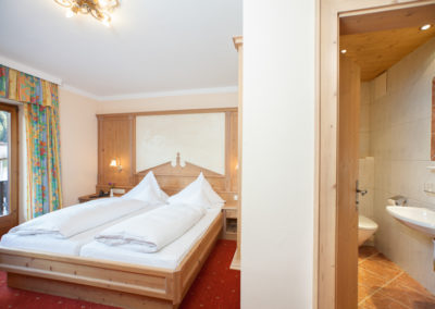 Doppelzimmer mit Doppelbett aus Holz