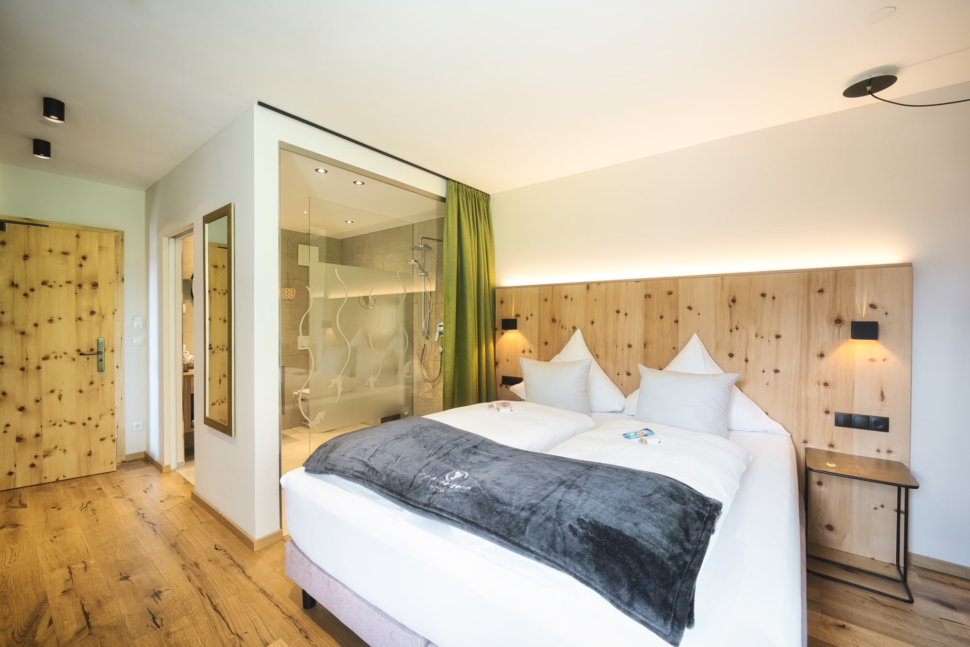 Modern eingerichtetes Gästezimmer aus Zirbe mit großem Doppelbett im Hotel die Arlbergerin in St. Anton am Arlberg