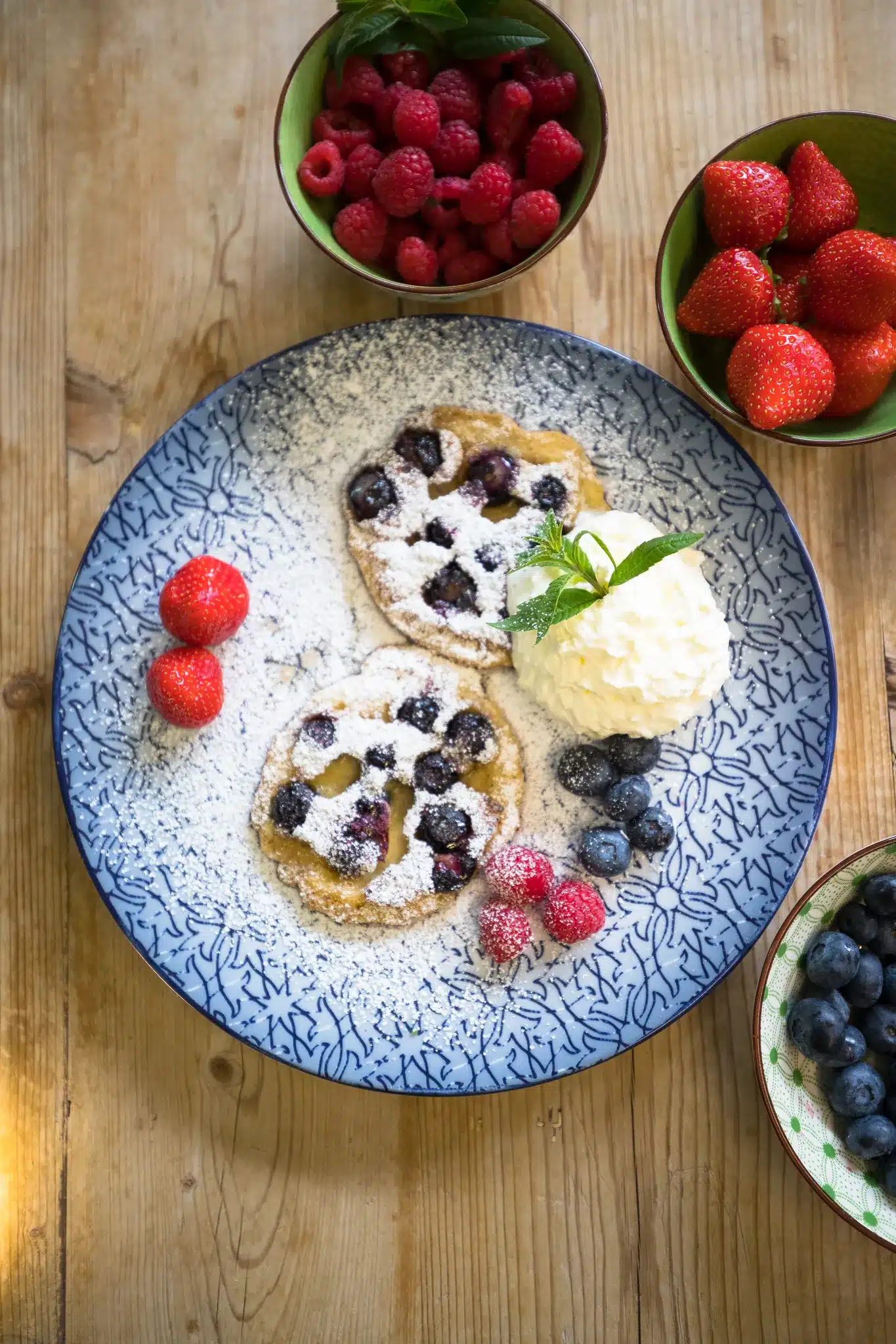 Startseite 126 Blueberry pancakes with cream and fresh berries, seen from above