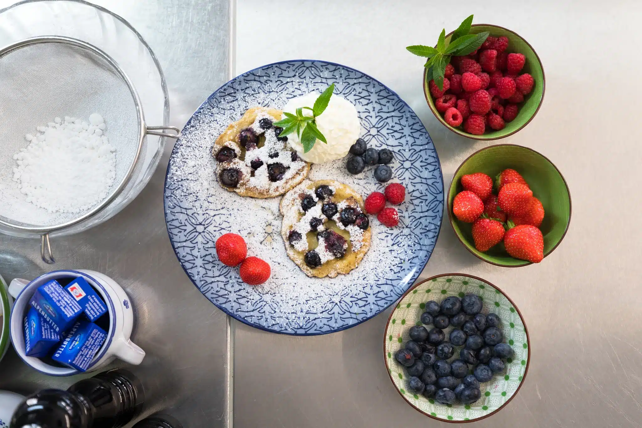 Startseite 130 Blueberry pancakes with berries and icing sugar, seen from above