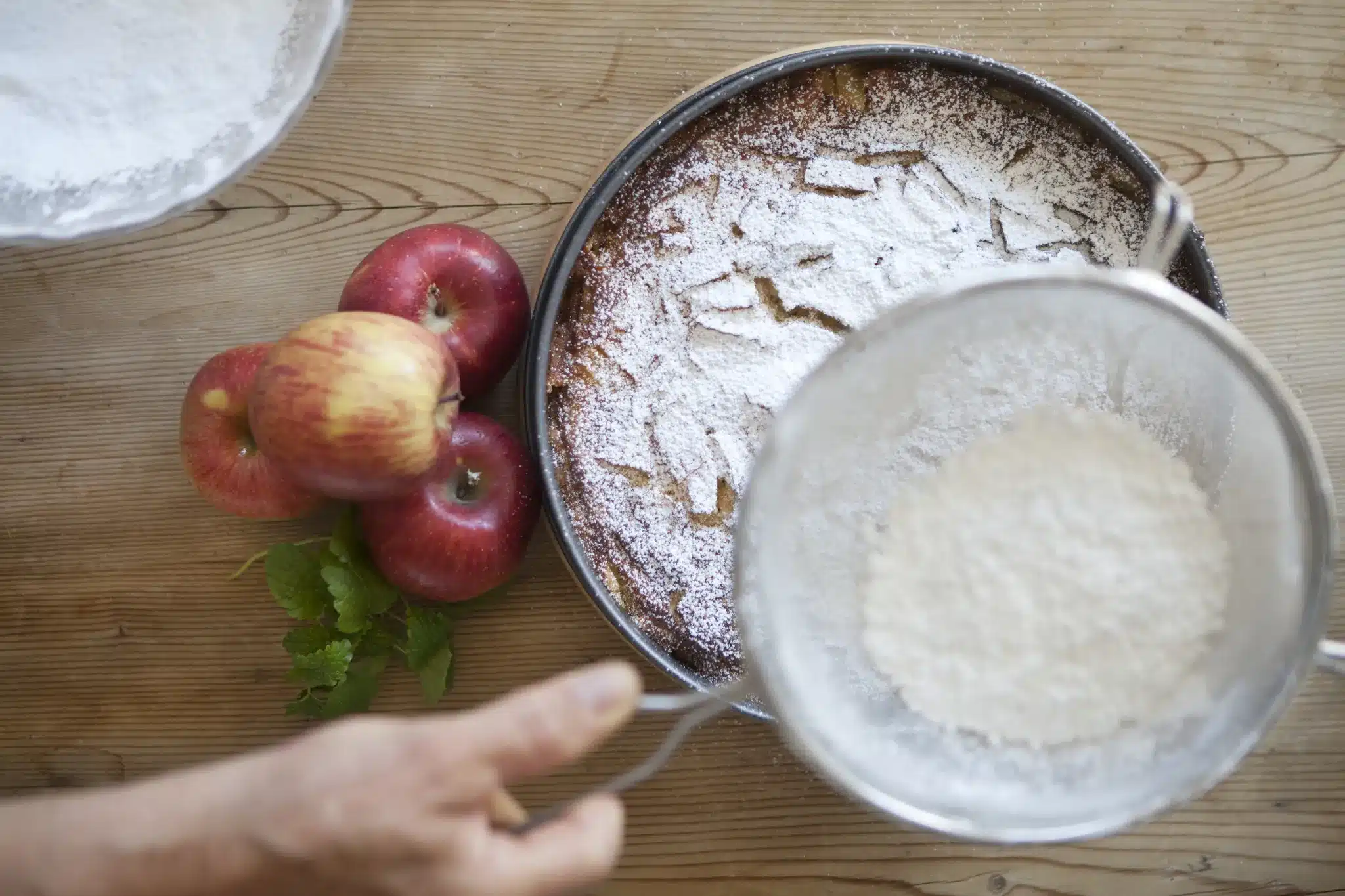 Startseite 67 Dusting a homemade apple cake with icing sugar