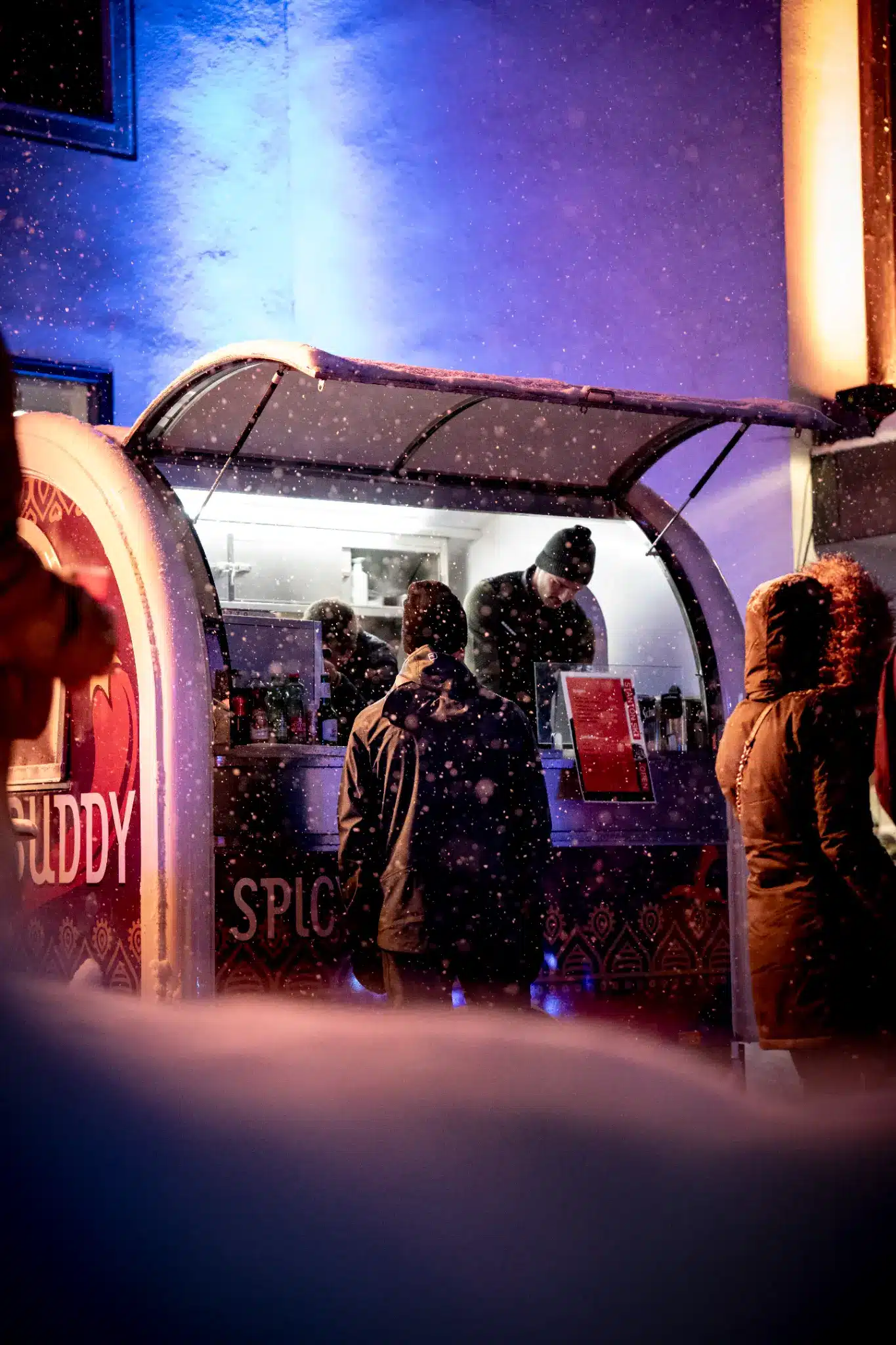 Ski Opening St Anton 2026 10 Visitors at a food truck during Stanton Ski Open in St. Anton as snow falls.